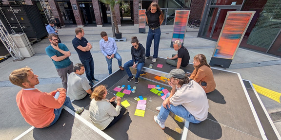 Several people are sitting around their notes at a creative workshop