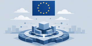 Eine isometrische Vektor-Illustration in kühlen Blautönen, die thematisch digitale Infrastruktur im Kontext der Europäischen Union darstellt. Im oberen Drittel des Bildes schwebt zentriert die Flagge der Europäischen Union – ein blaues Rechteck mit einem Kreis aus zwölf gelben Sternen. Unterhalb der Flagge befindet sich auf einer graublauen Ebene eine komplexe, futuristische Struktur, die auf einem kreisförmigen, mehrstufigen Fundament ruht. Diese Struktur besteht aus mehreren blauen Quadern unterschiedlicher Größe, die um einen zentralen Würfel angeordnet sind. Weiße Verbindungslinien und kleine Punkte zwischen den Elementen suggerieren Vernetzung, Datenflüsse oder das Layout einer Computerplatine. Im Hintergrund sind stilisierte, weiche weiße Wolken sowie am Horizont die minimalistische Silhouette einer Stadtlandschaft in hellem Grau zu erkennen. Das gesamte Bild vermittelt durch den sauberen, geometrischen Stil und die Farbpalette Modernität und technologische Ordnung.