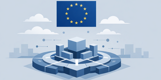 An isometric vector illustration rendered in monochromatic shades of blue and grey, depicting themes of digital infrastructure and governance. At the top center, the flag of the European Union is clearly displayed with its circle of twelve yellow stars on a blue field. Beneath the flag sits a stylized, complex geometric structure resting on a circular, tiered base. This structure features a central cube surrounded by smaller rectangular blocks and connecting lines, resembling a digital platform, server architecture, or a circuit board. Floating around the structure are small spheres and lines indicating connectivity. In the background, stylized white clouds float above a faint, minimalist city skyline silhouette on the horizon. The image utilizes a flat design aesthetic to symbolize technology under European oversight.