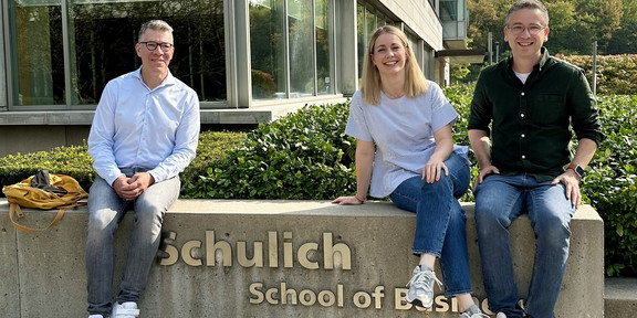 Photo of Dr. Köcher, 3rd from left with 2 colleagues, in front of the Schulich School of Business in Torontol of Business in Toronto