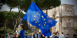 Junge Frau Europaflagge in Menschenmenge.