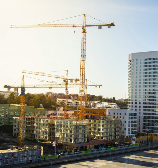 Hochhäuser im Bau, mit sehr hohen Kränen und modernen Hochhäusern im Hintergrund.
