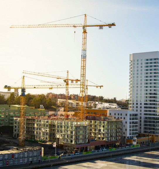 Hochhäuser im Bau, mit sehr hohen Kränen und modernen Hochhäusern im Hintergrund.