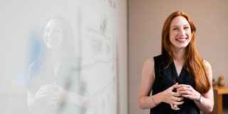 Smiling woman in front of white board