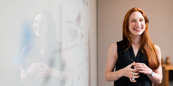 Lächelnde Frau steht neben White Board