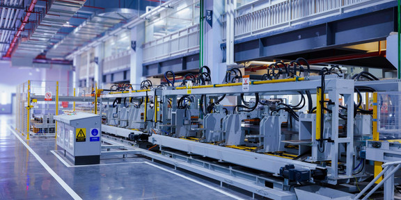 A production line with several machines lined up in a row in a modern factory.