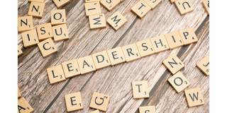 “Leadership” written with Scrabble tiles, on wooden slats