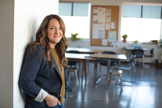 Photo: Woman in business attire, in front of a seminar room.