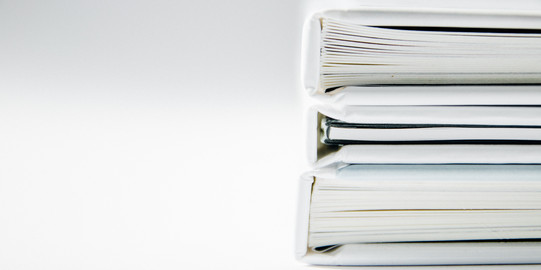 Photo: white full folders stacked horizontally, light background