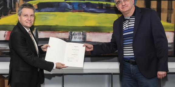 Das Foto zeigt den Rektor der TU Dortmund Prof. Dr. Manfred Bayer bei der Übergabe der Urkunde an Honorarprofessor Dr. Achim Schröder (v.r.n.l.)