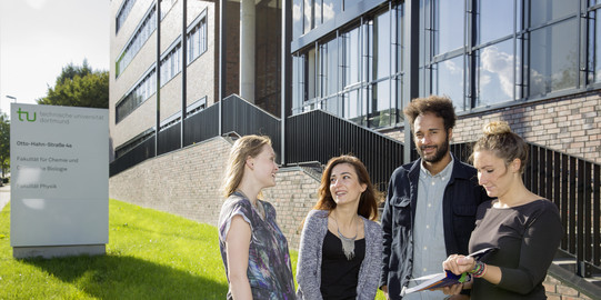 Vier Studierende stehen vor dem neu errichteten Physikgebäude.