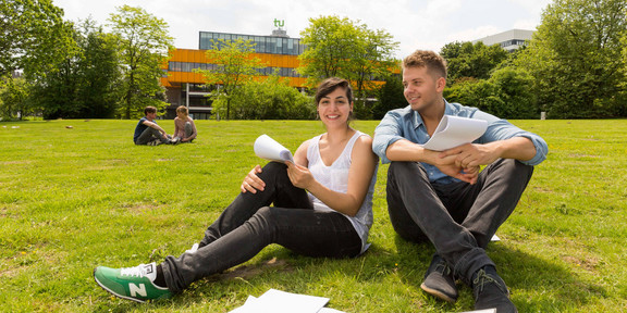 Two students sitting on a lawn