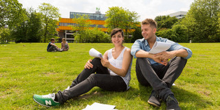 Two students sitting on a lawn