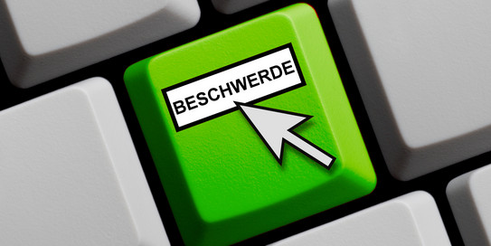 Eine grüne Taste mit dem Wort Beschwerde und einem hinweisenden Mauspfeil.