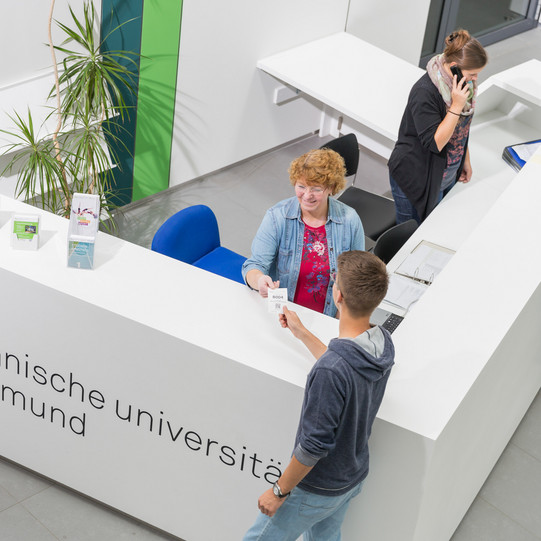 Ein Student gibt seine Wartenummer bei der Studienberatung ab.