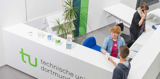 Studierendenberatung Ein Student gibt seine Wartenummer bei der Studienberatung ab.