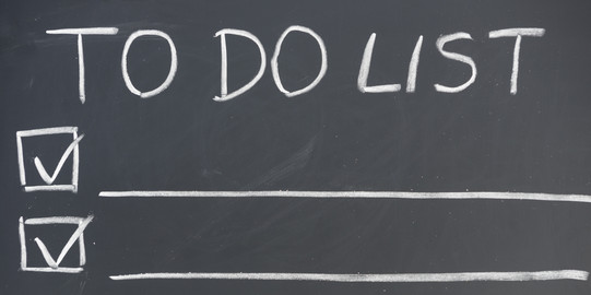 An einer Tafel steht die Überschrift „TO DO LIST”, darunter sind drei Zeilen mit Kästchen an der linken Seite und einem lange Unterstrich. In zwei Kästchen ist ein Haken gesetzt.