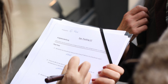 A woman is completing a questionnaire concerning eye tracking